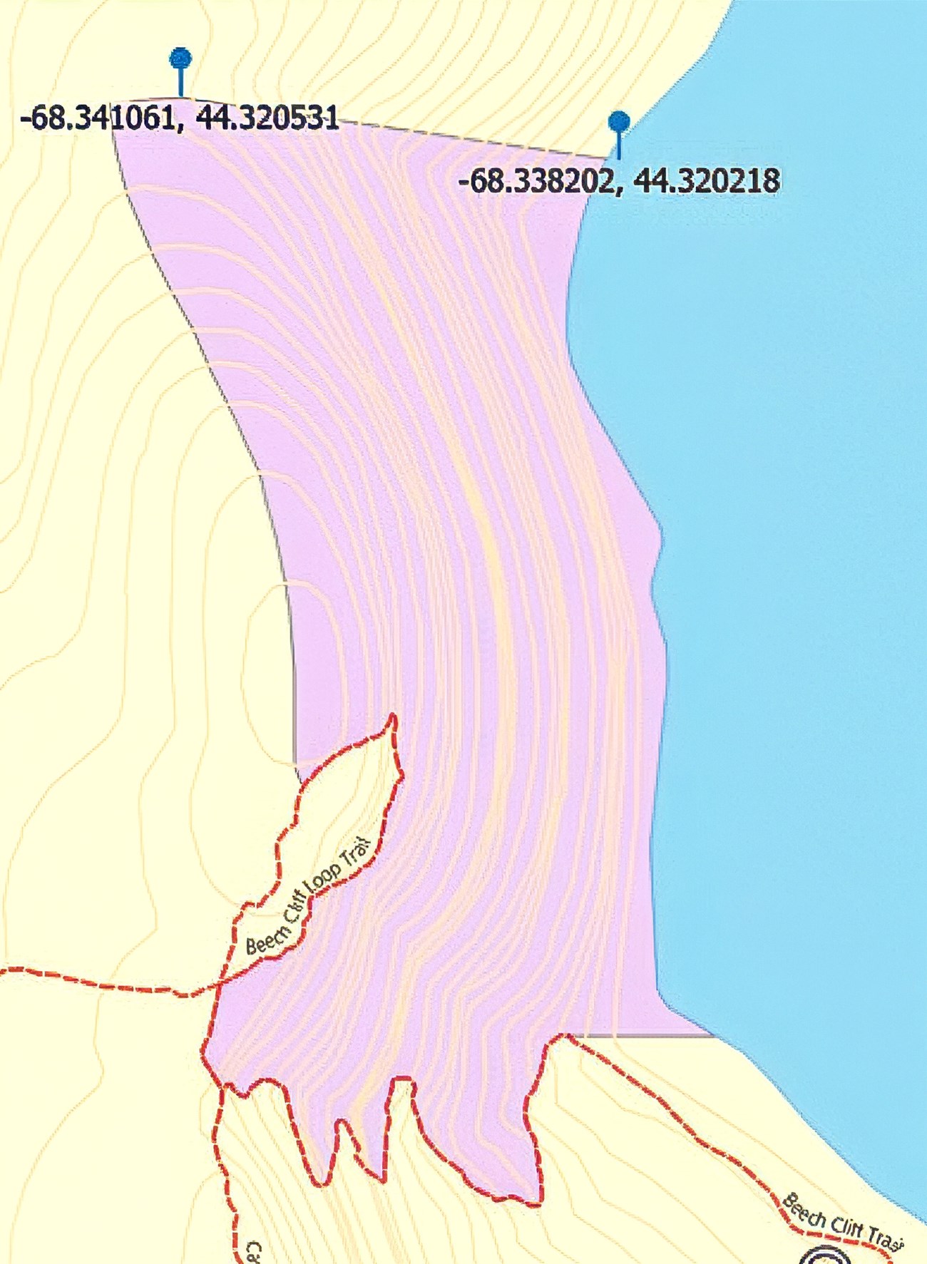 Shaded area forms band between shoreline and cliff top, with lobed projections on south side. Open trails run along border at top. None are closed.
