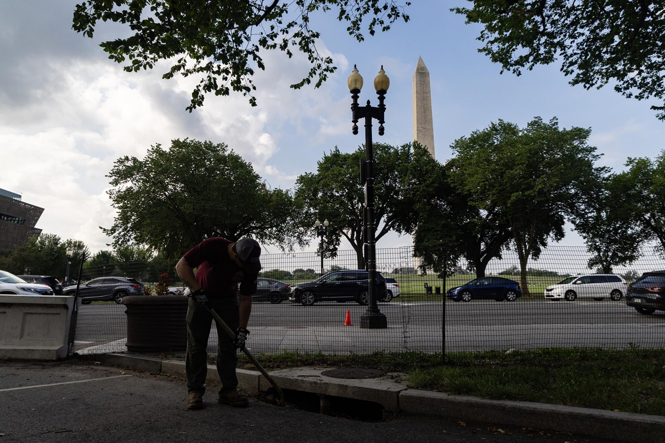 Traditional Trades Advancement Program (TTAP) intern Brenton Tate clears debris from a storm drain at The White House and President’s Park in Washington, July 22, 2025.