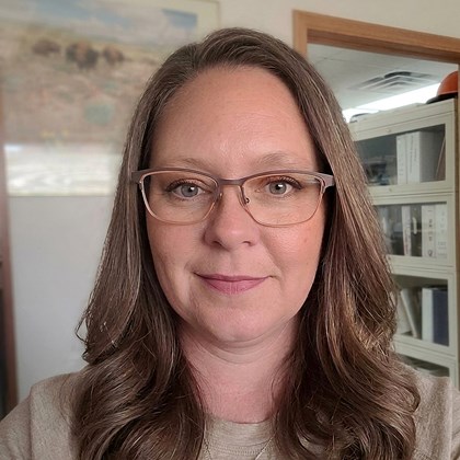 Headshot of smiling woman with brown hair and glasses