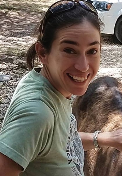 Smiling woman in green shirt with dog