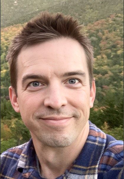 Face of smiling man in blue plaid shirt