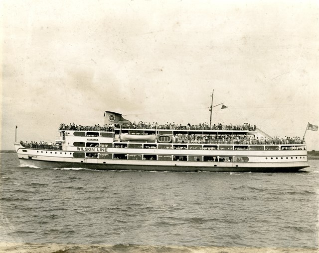 Ferry sailing on the water with a lot of people on deck.