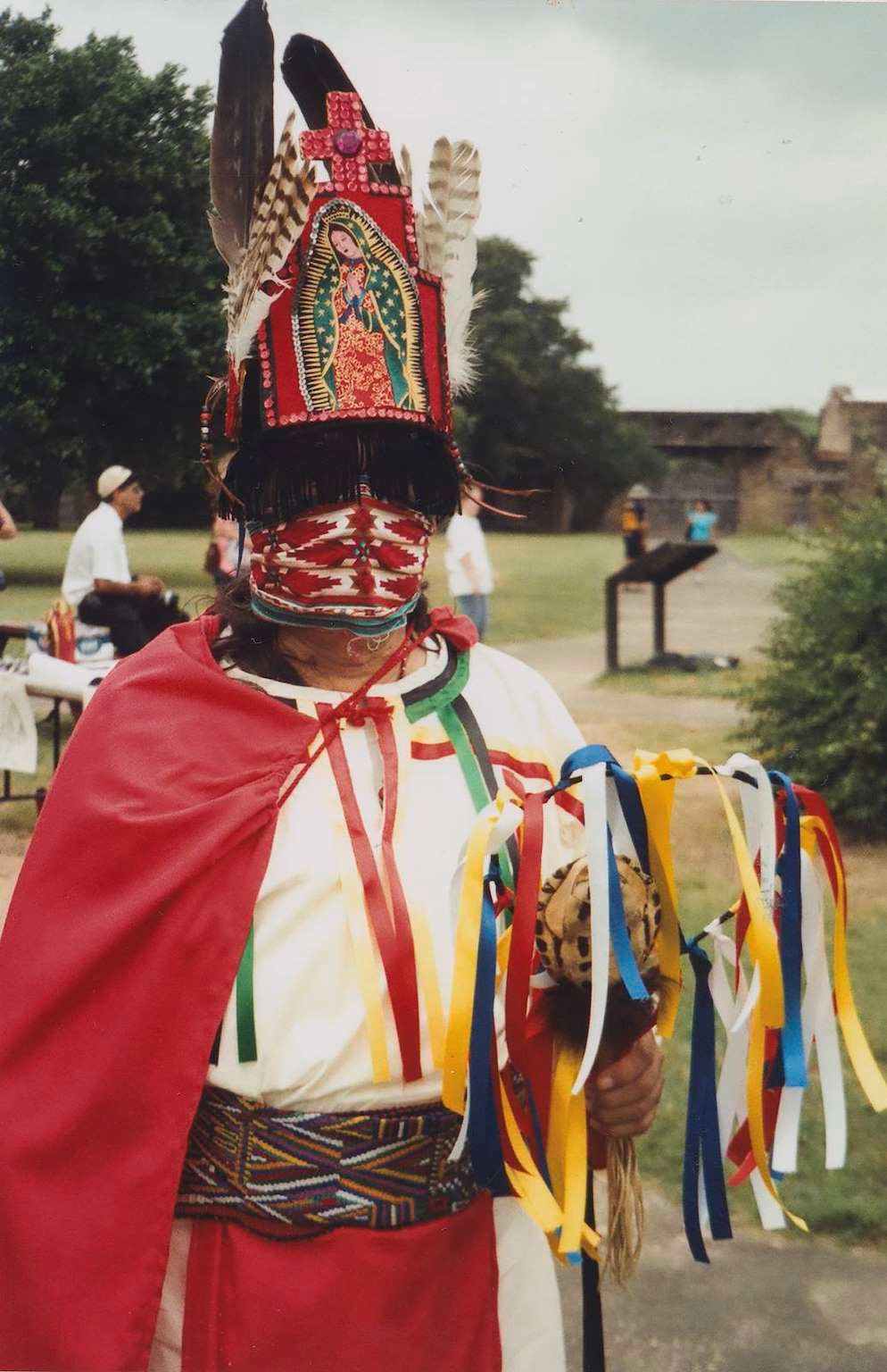 Man in traditional clothing in front of a historic site