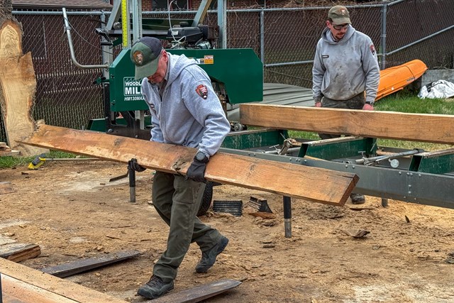 NPS maintenance members stacking milled boards. 