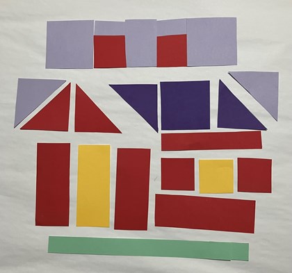 Paper laid out to form parts of a quilt block in the shape of a house, top blocks closer together.