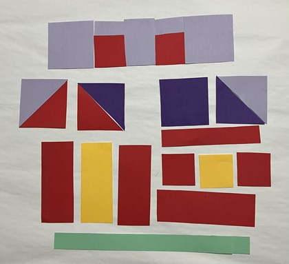 Paper laid out to form parts of a quilt block in the shape of a house, pieces spread.. 