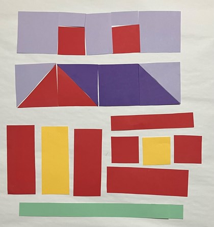 Paper laid out to form parts of a quilt block in the shape of a house, 1st and 2nd row together, other pieces scattered.