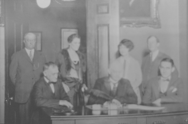 A ground of people sitting at a table in black and white