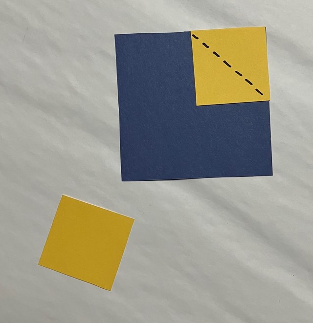  One large blue square and 2 yellow squares, one yellow on the blue square with dotted line.
