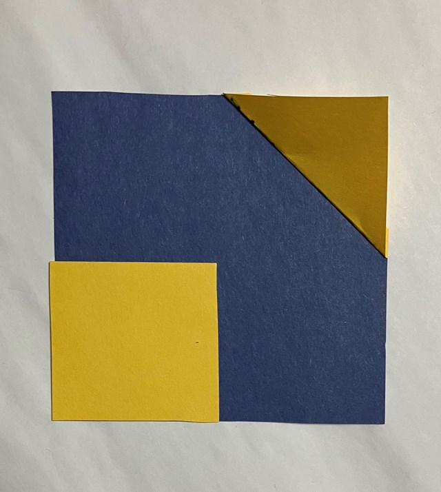  One large blue square and 1 yellow square together. One yellow triangle in the corner. 