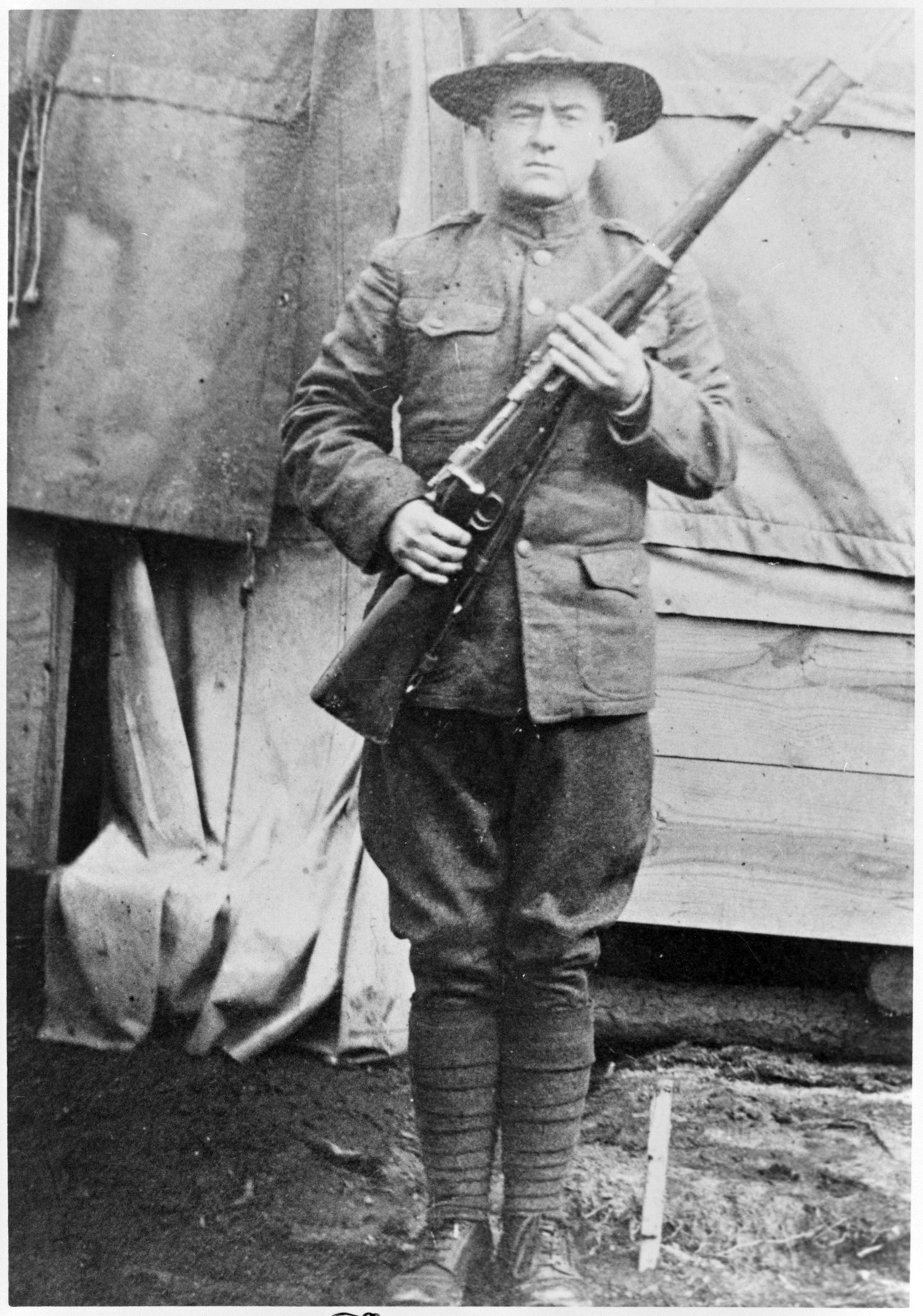 A man standing in a military uniform holding a musket.