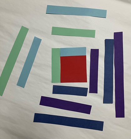 Strips of paper in shades of purple, green, and blue around a red square.