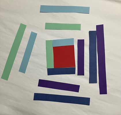 Strips of paper in shades of purple, green, and blue around a red square.