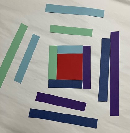 Strips of paper in shades of purple, green, and blue around a red square.