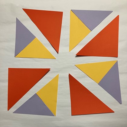 Triangles of different colors laid out in a block spread out.