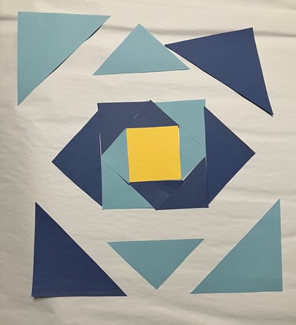 Blue and yellow paper laid out on a white background in triangle and square shapes.