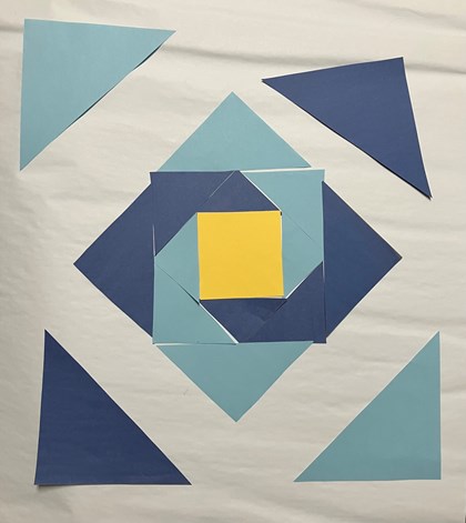 Blue and yellow paper laid out on a white background in triangle and square shapes.