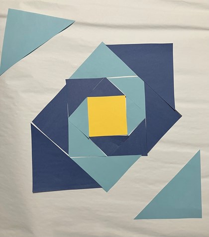 Blue and yellow paper laid out on a white background in triangle and square shapes.