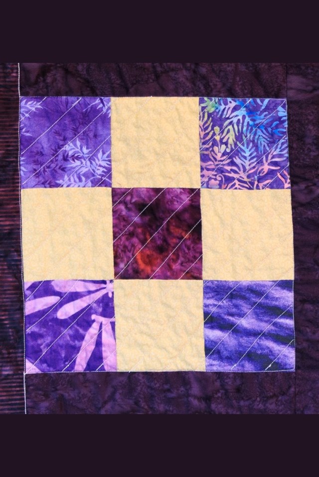 A purple and yellow nine patch quilt block