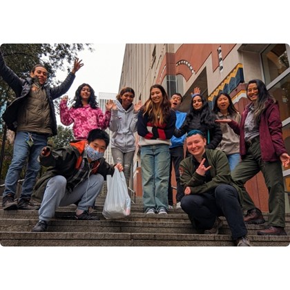 Group of people smiling for a photo while on staircase outside