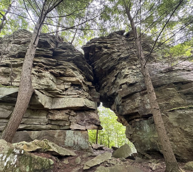 Rock arches stand tall in the woods.