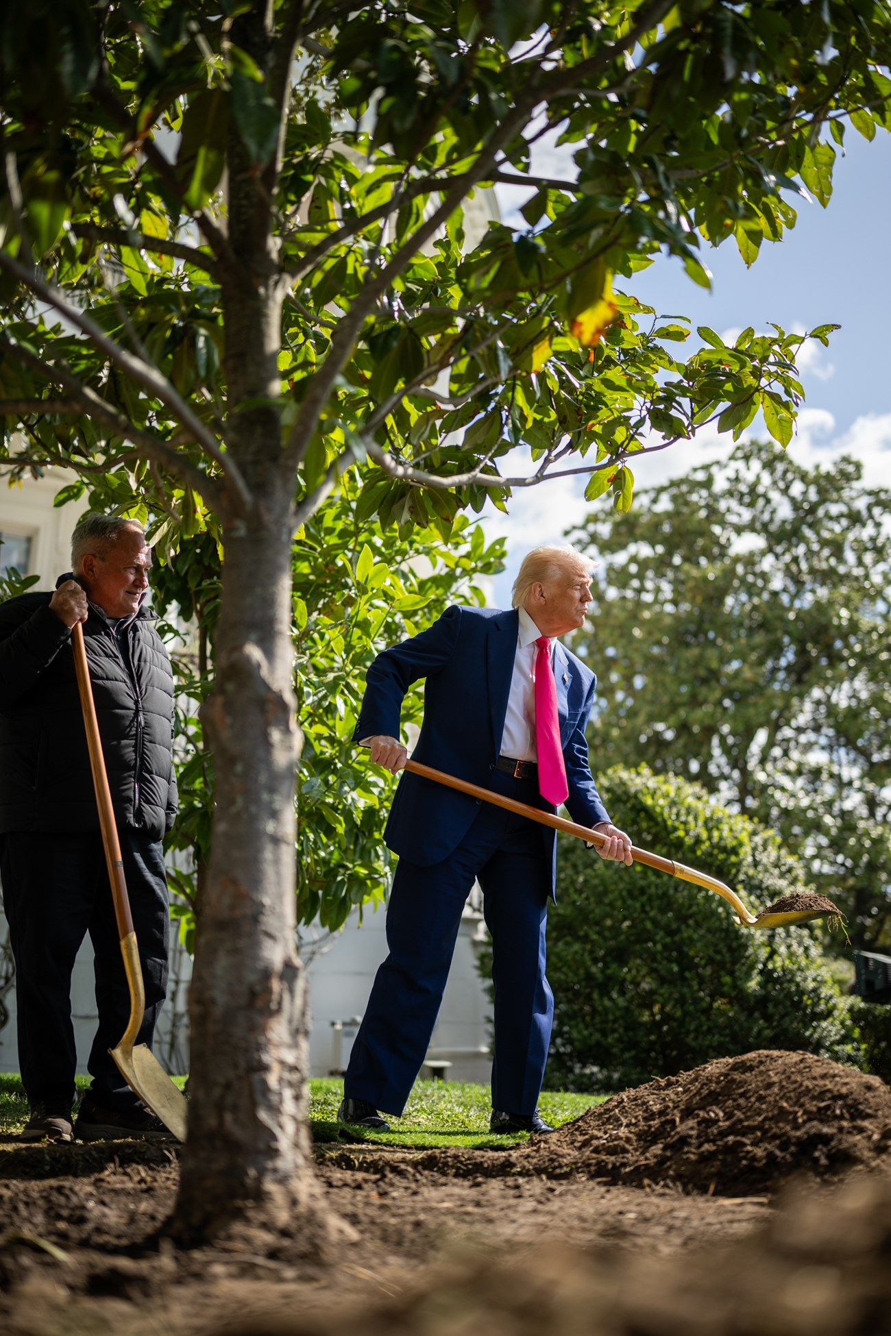 President Donald J. Trump lifts a shovel of planting soil during tree planting ceremony