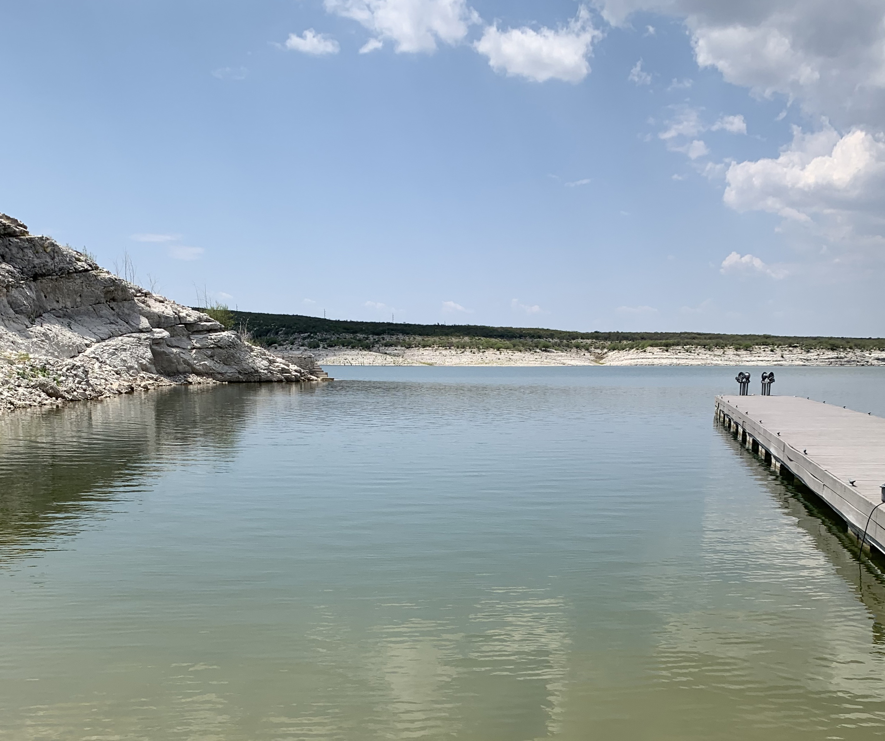 Boat ramp with hardly noticeable algal swirl at end of a boat dock toward shore.