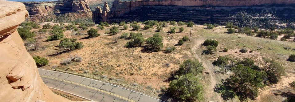 black and white photo of several long, wooden barracks-style buildings with a central courtyard, canyon cliffs in the background