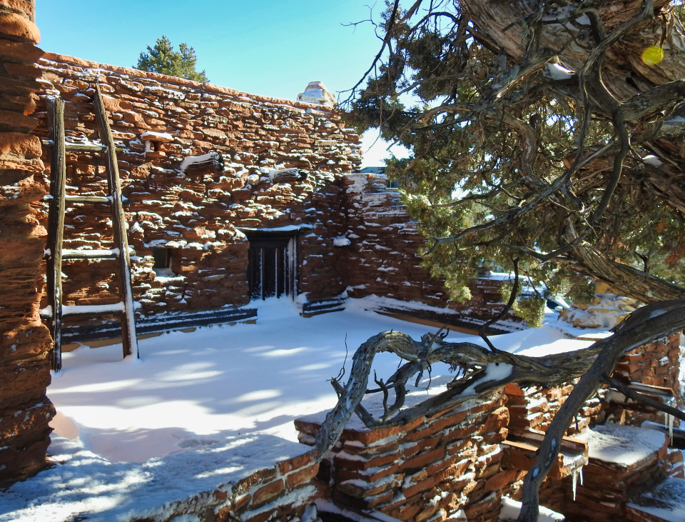A stone structure with people, trees, and a ladder