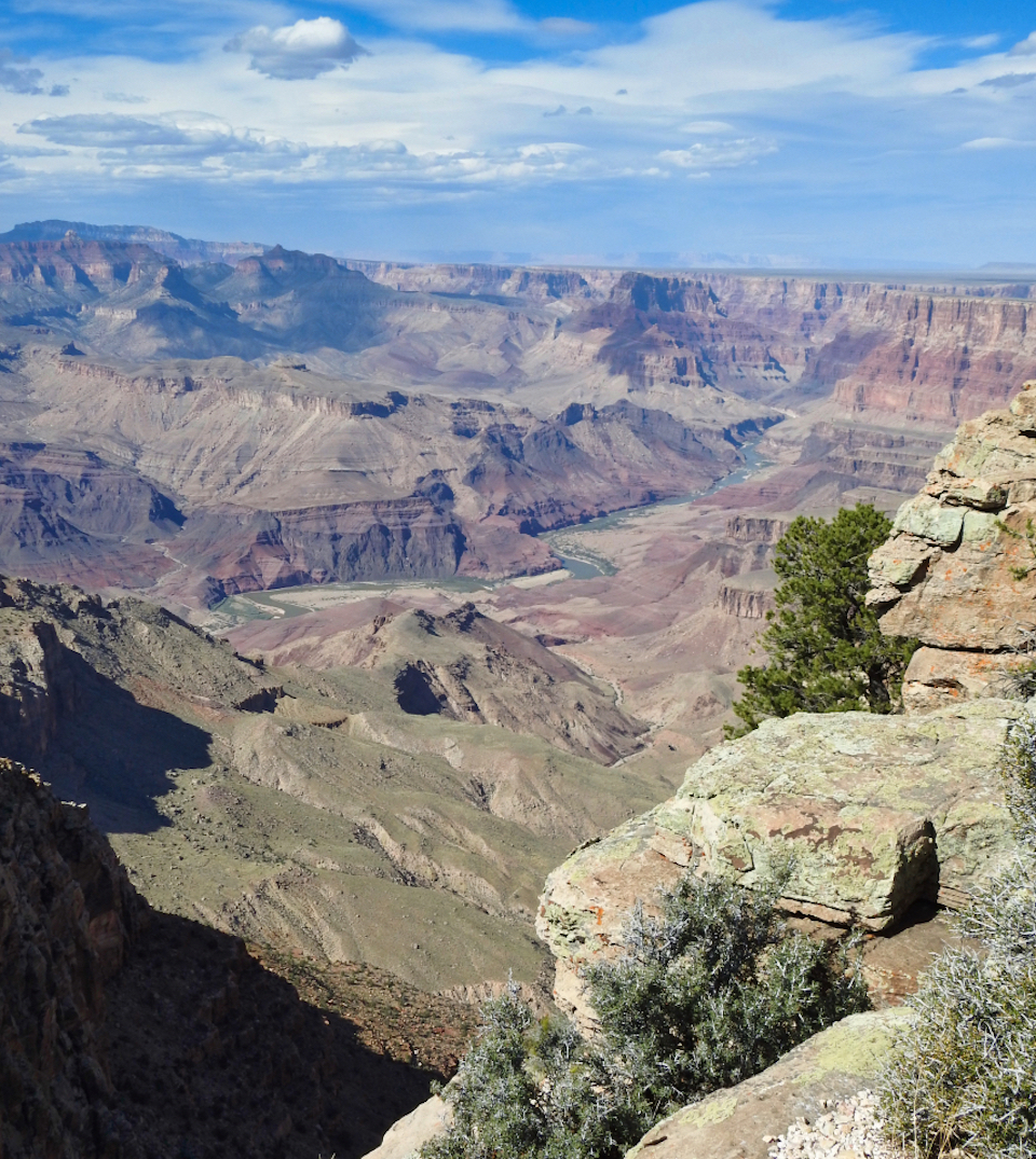 Man sitting on rock looking at river canyon