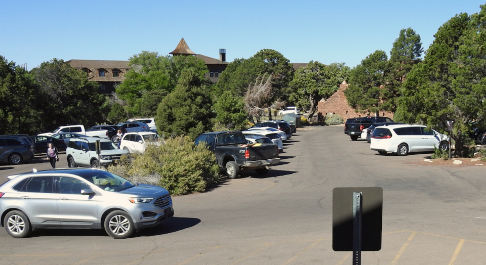 Multiple cars parked with buildings in background