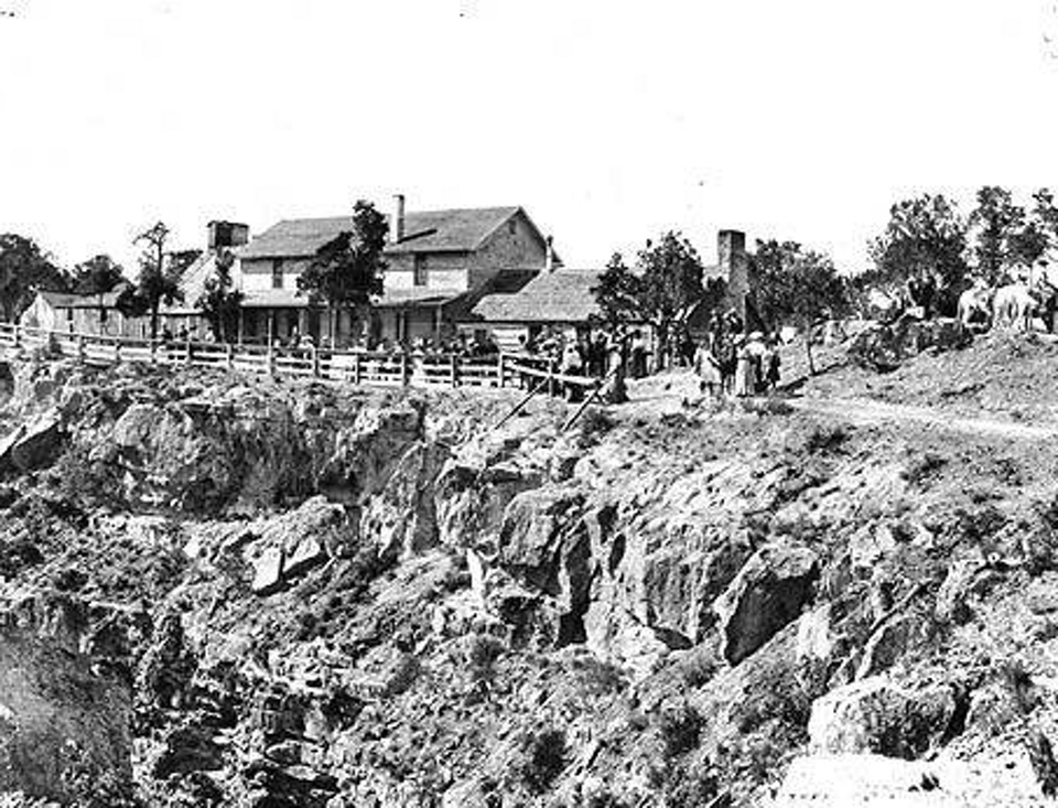 Cliff with fence and buildings behind