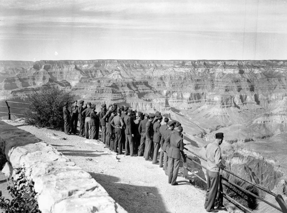 Group of soldiers line railing on edge of canyon