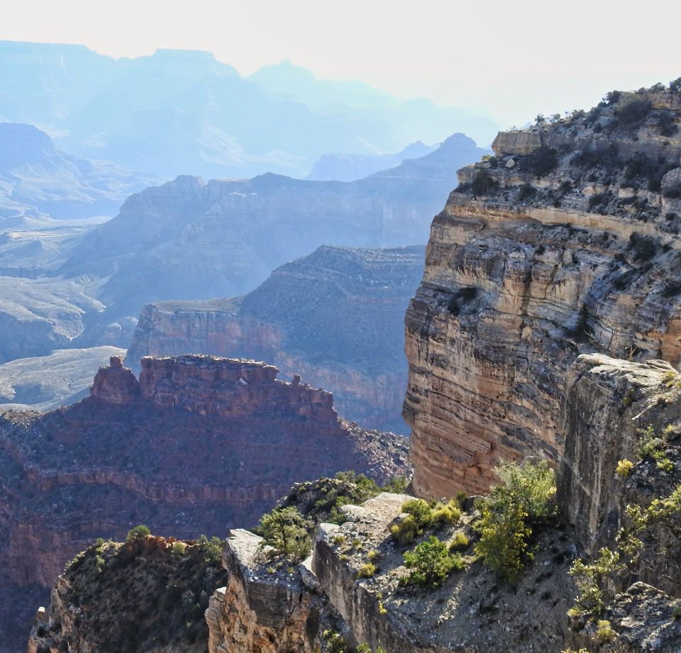 Painting of cliffs and bushes atop canyon walls