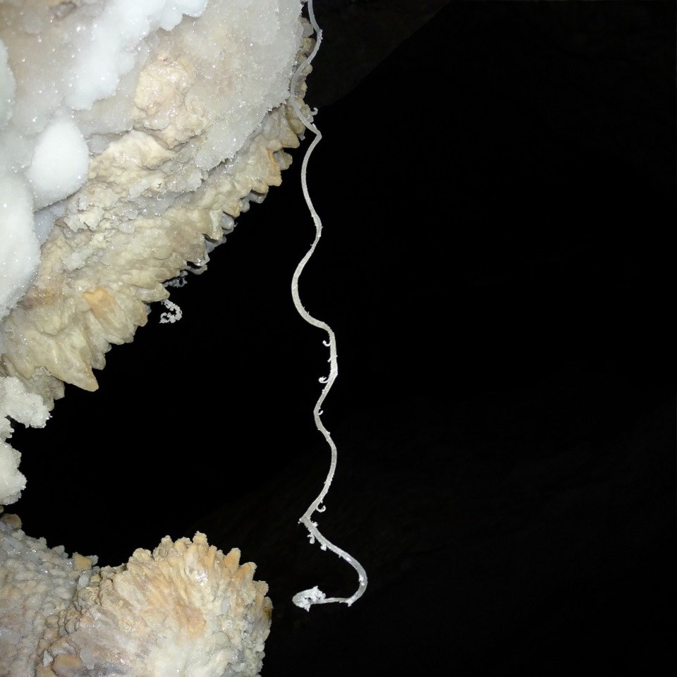 Hair-like strands of gypsum hand down to cotton-like pile of gysum.