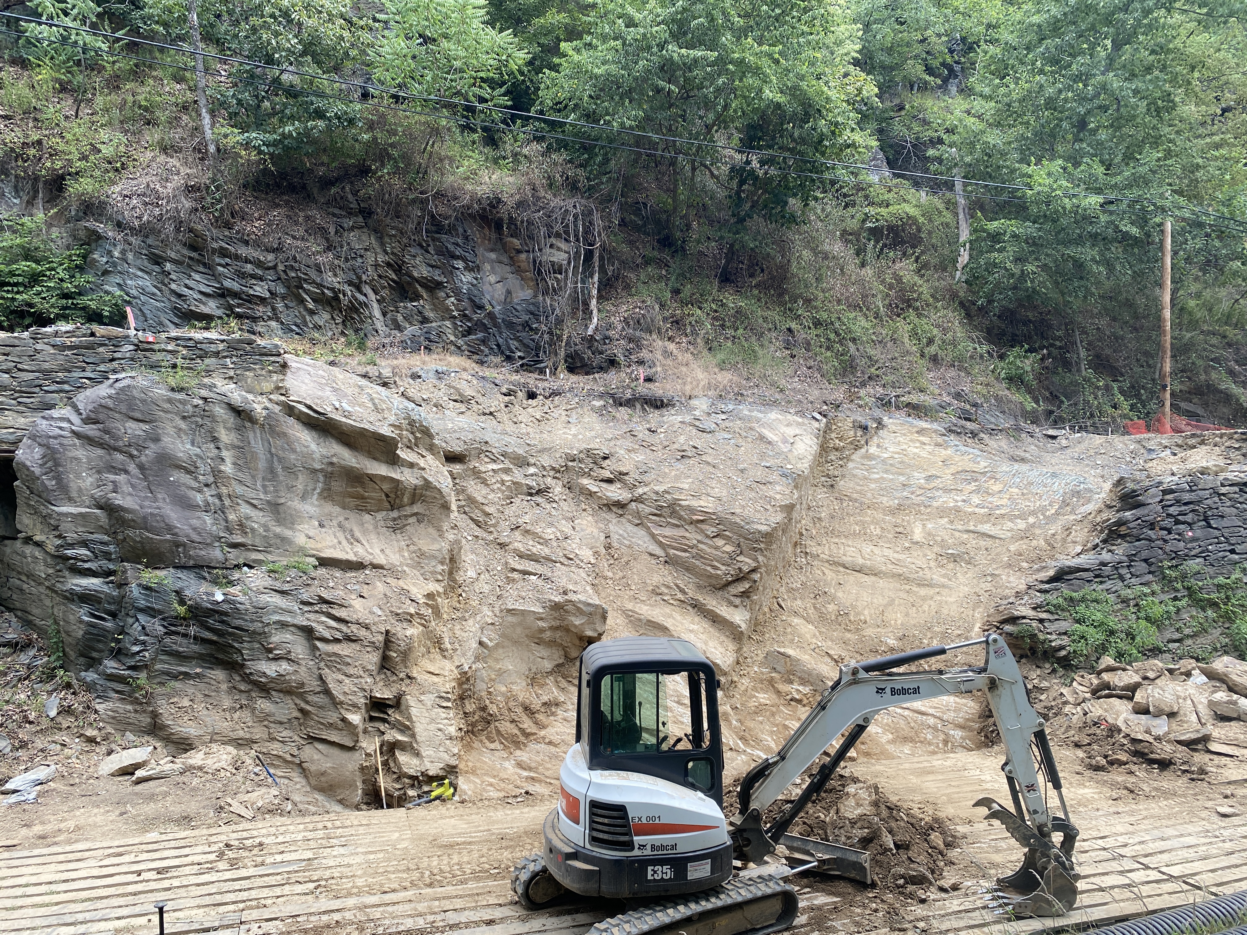 A sagging stone wall holding up a road