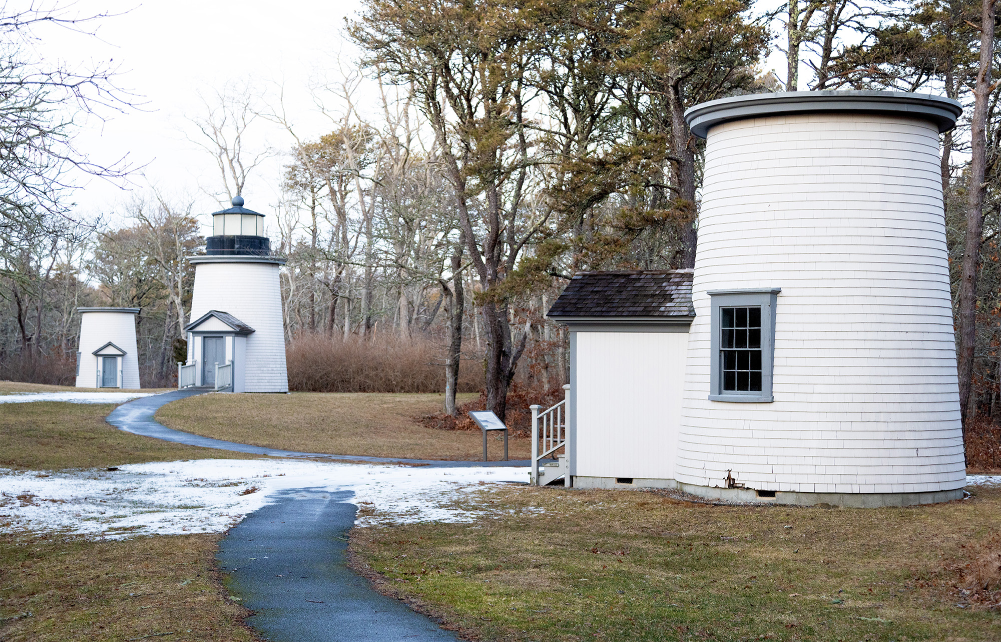 Three lighthouses are visible on a sea cliff.