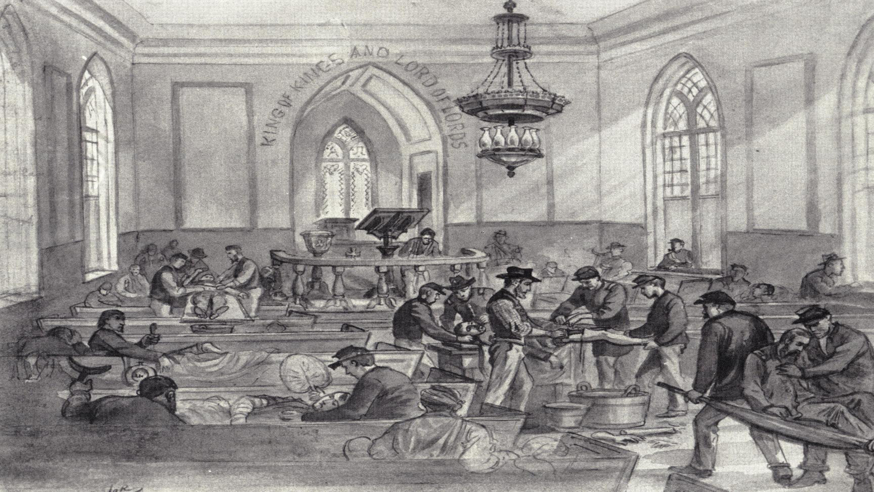 Chapel's interior lined with wooden pews. A chandelier hangs from the ceiling, a large bible rests on a lectern in the altar.