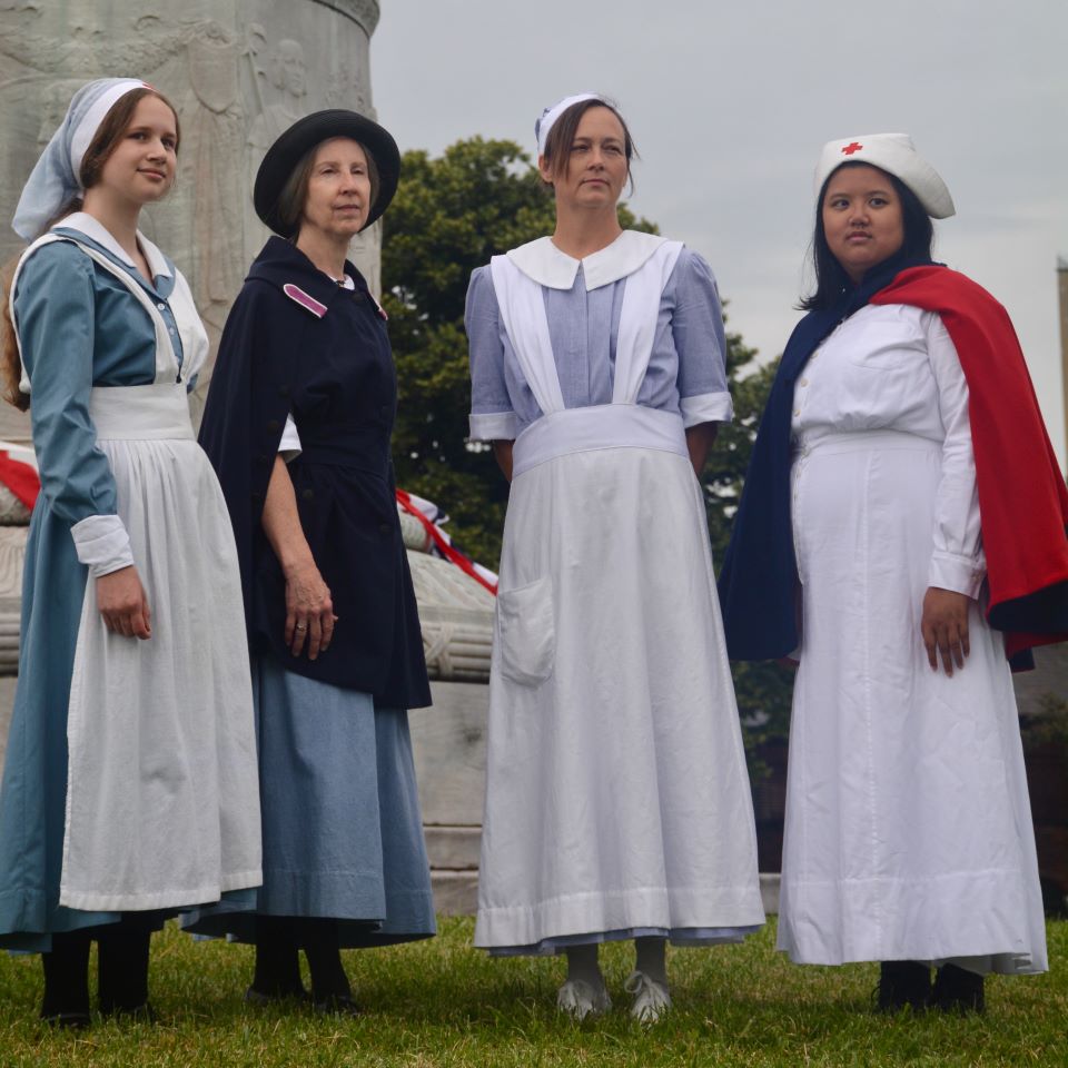 Standing in front of a probable hospital building, this pair of nurses pose for a picture.