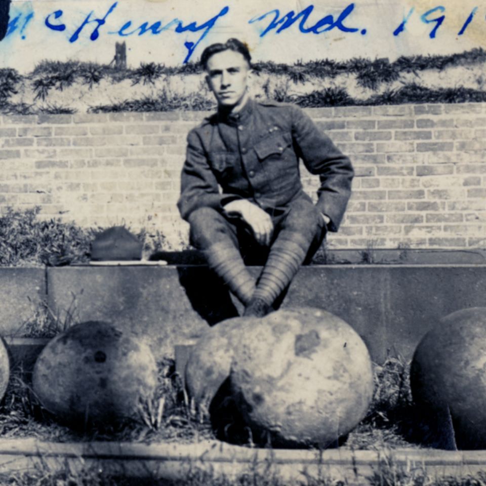 A solider in 1919 sits here, with his feet resting on cannon balls used as Fort McHenry’s ammunition.
