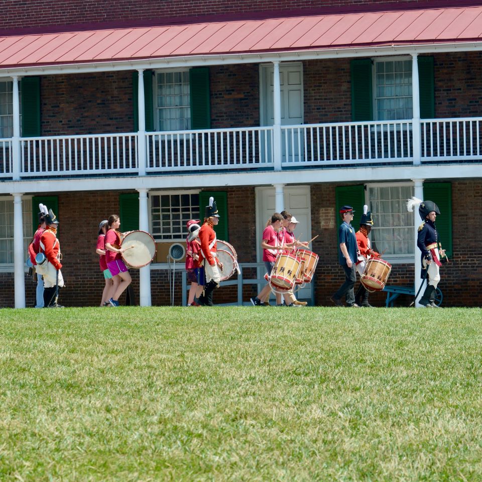 Marching in front of buildings that no longer exist, these army musicians play their tunes as they parade across the Fort’s grounds.