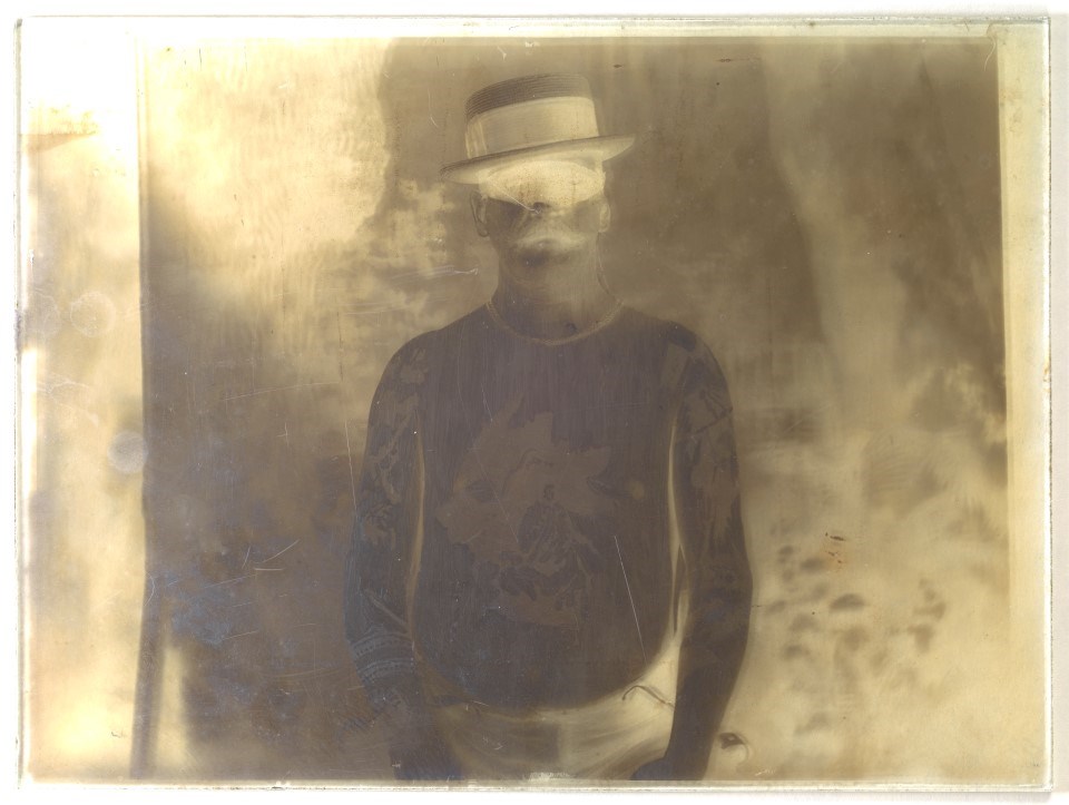 Glass negative showing a man in a hat