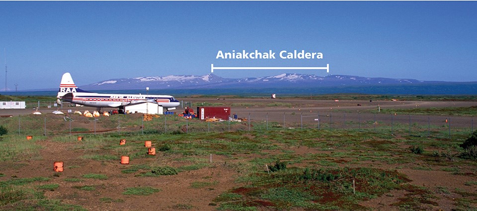 photo of a distant mountain range with an airplane in the foreground