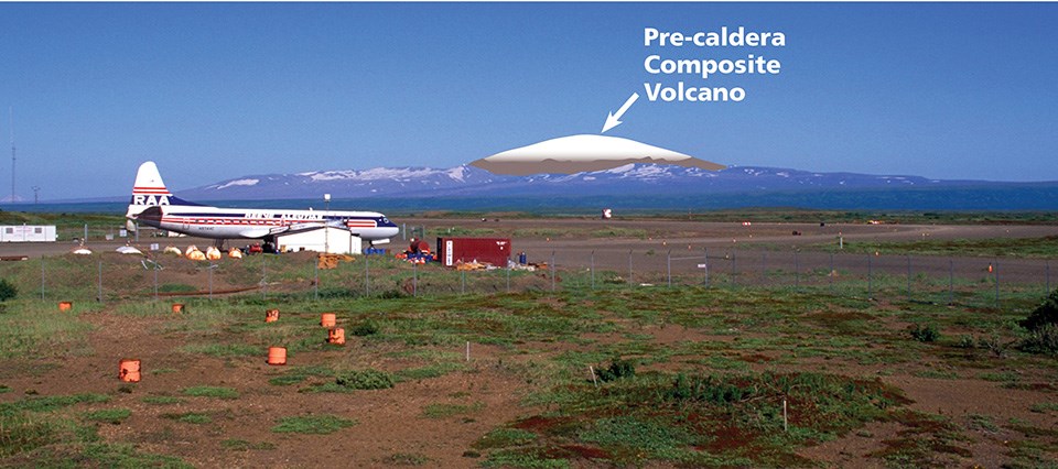 photo of a distant mountain range with an airplane in the foreground