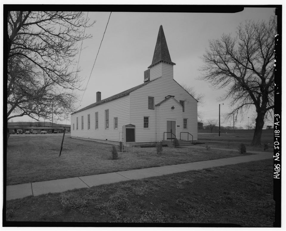 Church with white paneling and dark colored steeple.