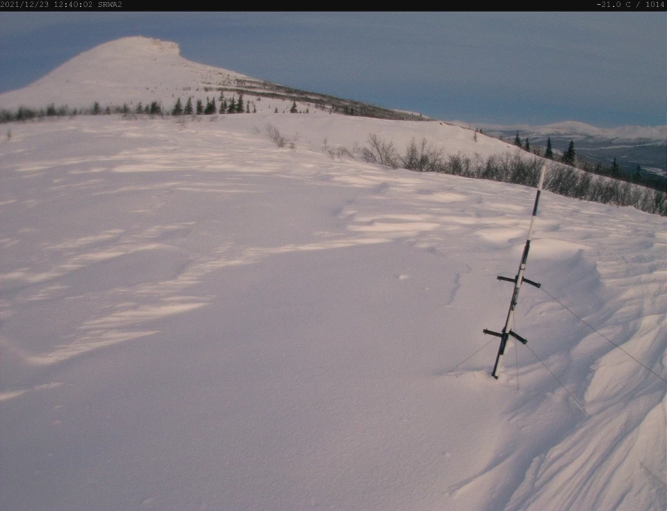 2 images showing snow accumulation on a mountain side in alpenglow