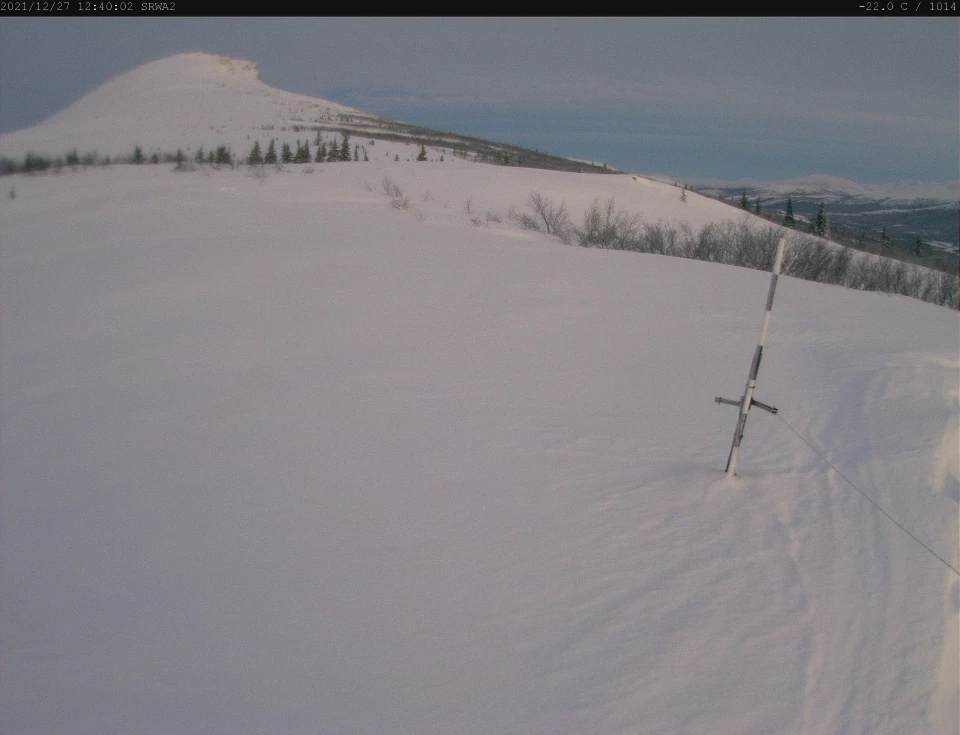 2 images showing snow accumulation on a mountain side in alpenglow