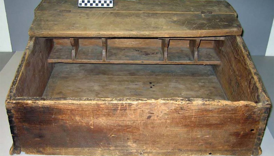 A wooden, boxy item that has a rough and faded surface.