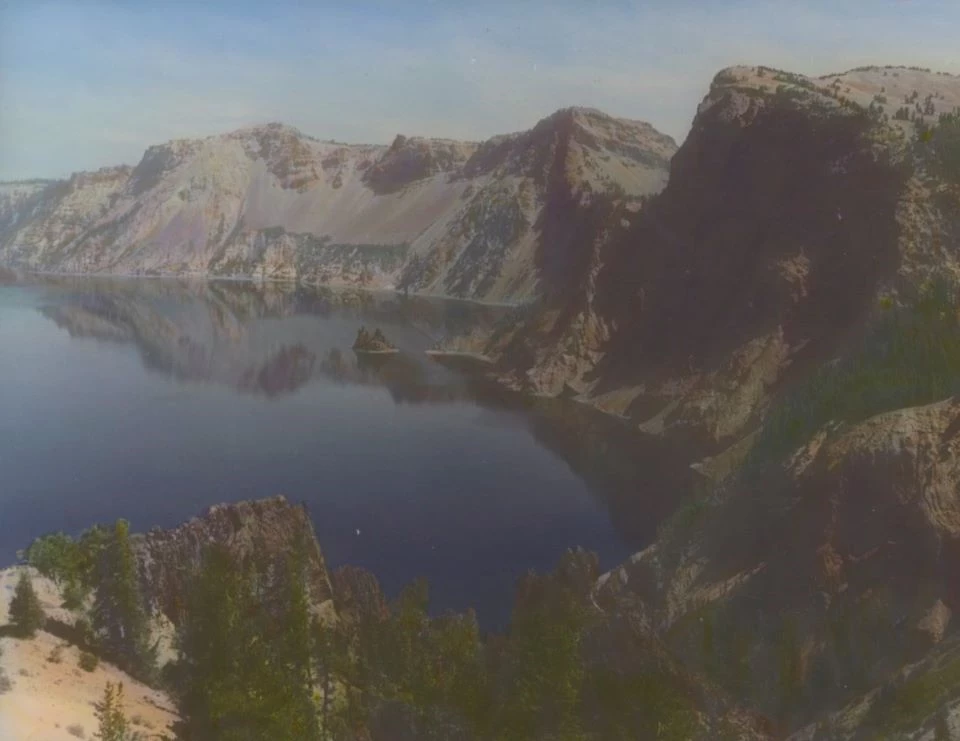 Black and white photo of a lake surrounded by steep-sided cliffs.