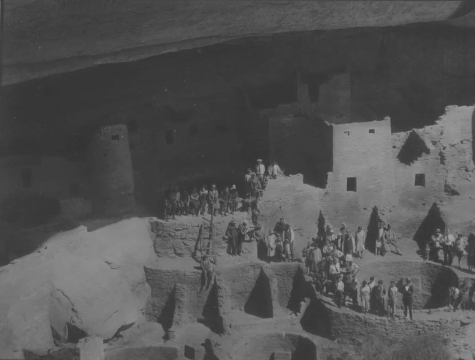 Black and white photo of people standing on stone ruins.